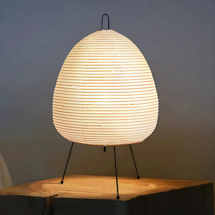 Egg-shaped paper lantern lamp with thin metal legs.