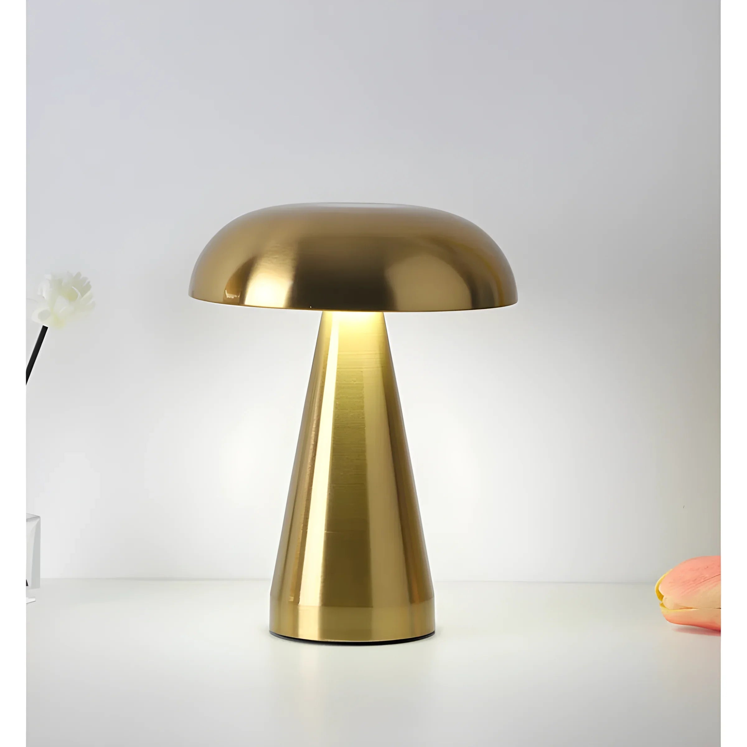 Gold-colored mushroom-shaped table lamp with a domed shade and cylindrical base.