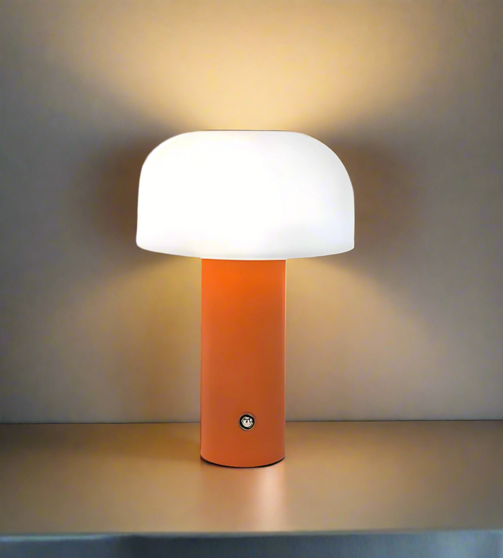 Modern table lamp with an orange cylindrical base and white dome-shaped shade.