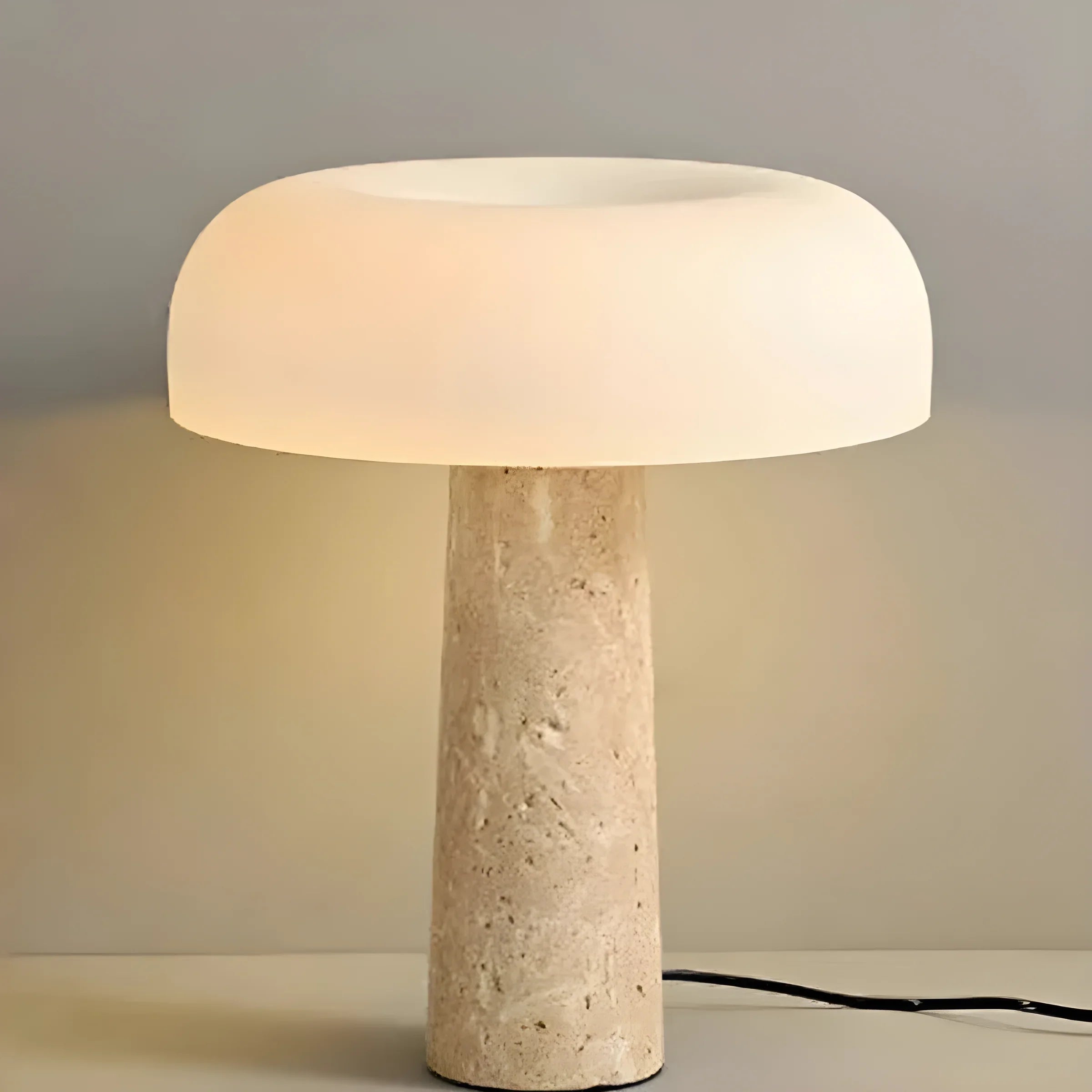 Mushroom-shaped table lamp with a stone base and glowing domed shade.