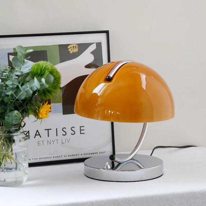 Orange dome-shaped table lamp with a chrome base.