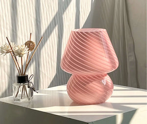 Pink glass table lamp with a swirled, textured design.