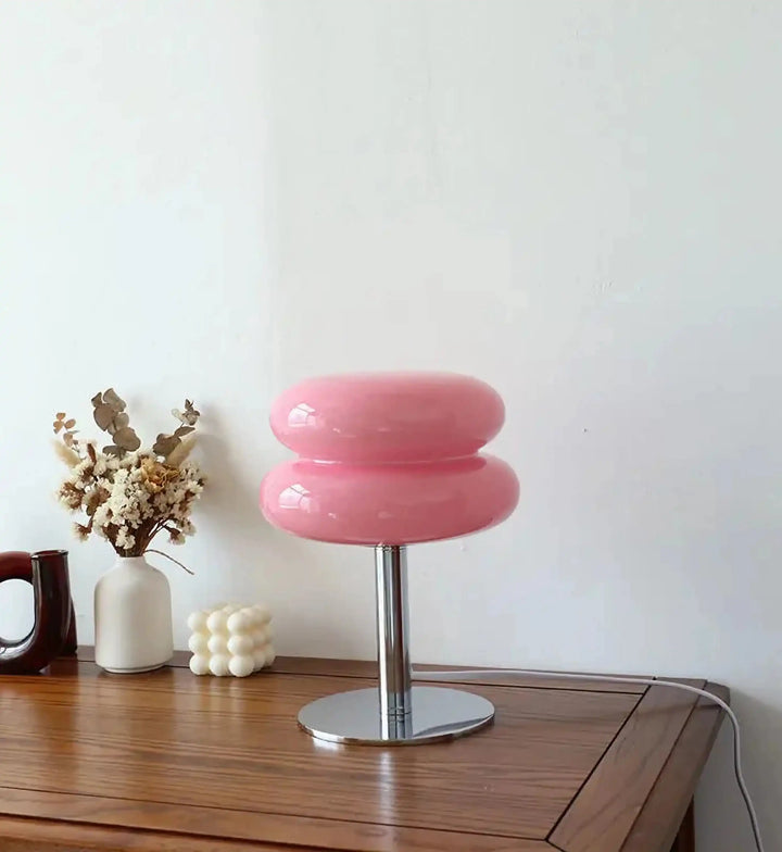 Pink, rounded stool with a metallic base and stem.