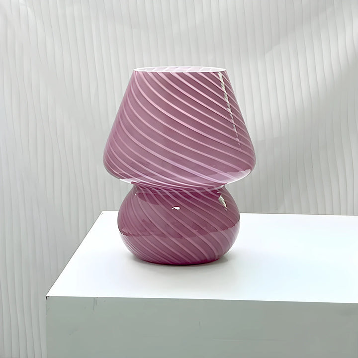 Pink glass lamp with swirled pattern.