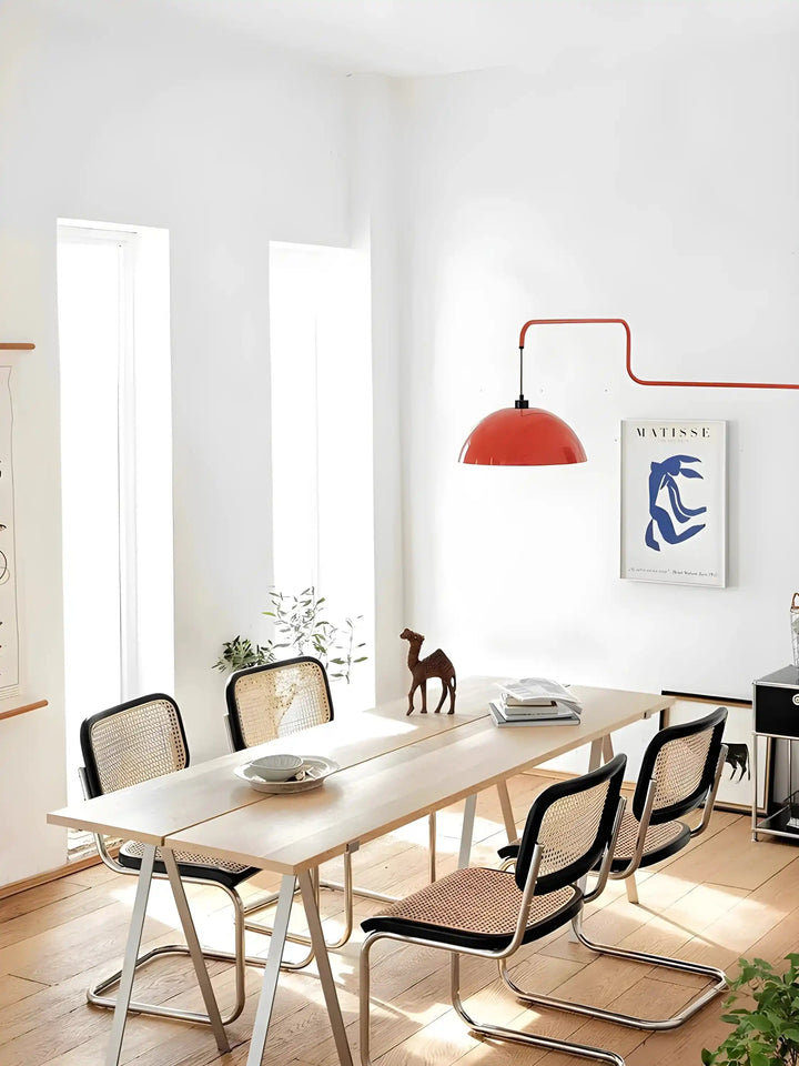 Wooden dining table with cane-backed chairs.