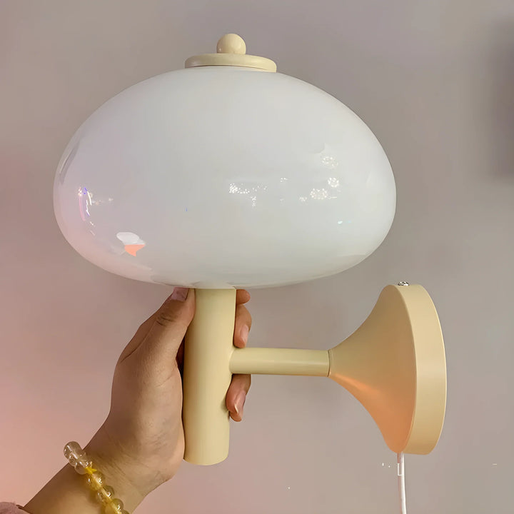 Retro-style wall lamp with a round white glass shade and beige base.