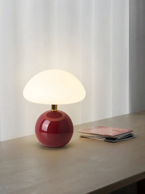 Spherical red table lamp with a white dome-shaped shade.