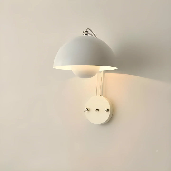 White dome-shaped wall sconce with a warm glow.